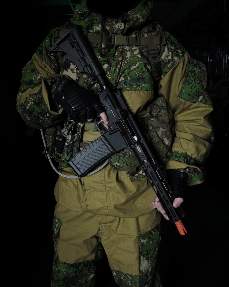 Person in camouflage uniform holding a Wolverine MTW HPA Airsoft rifle against a dark background