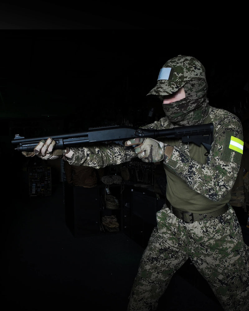 Person in camouflage holding a Double Eagle pump-action airsoft shotgun in a dark setting
